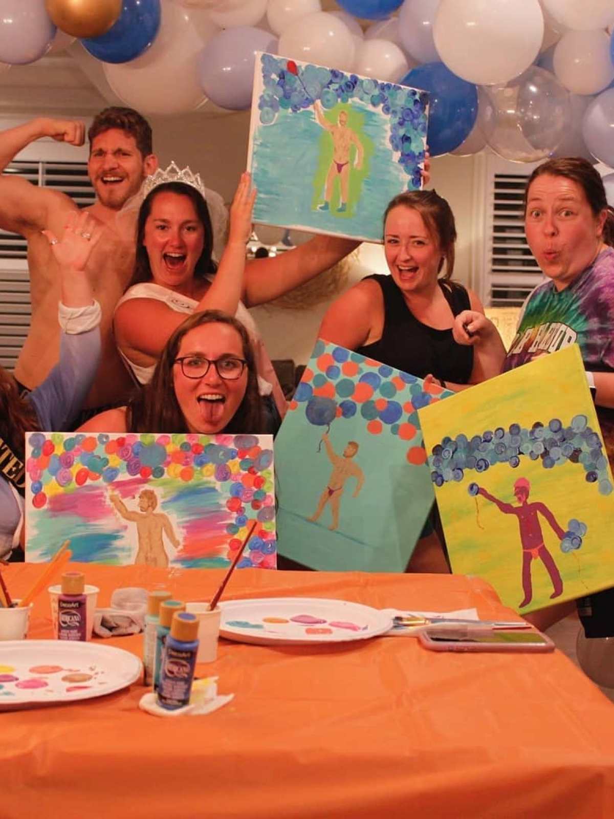 a group of people sitting at a table with a birthday cake