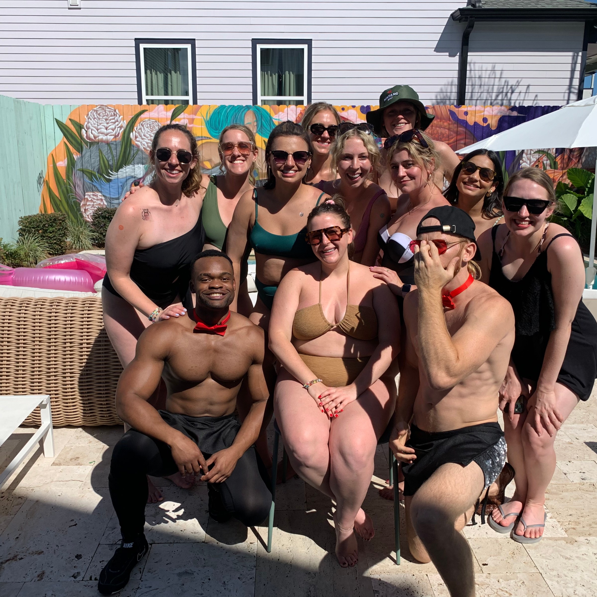 a group of people sitting on a bench posing for the camera