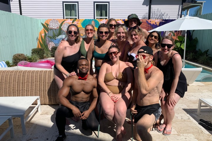 a group of people sitting on a bench posing for the camera